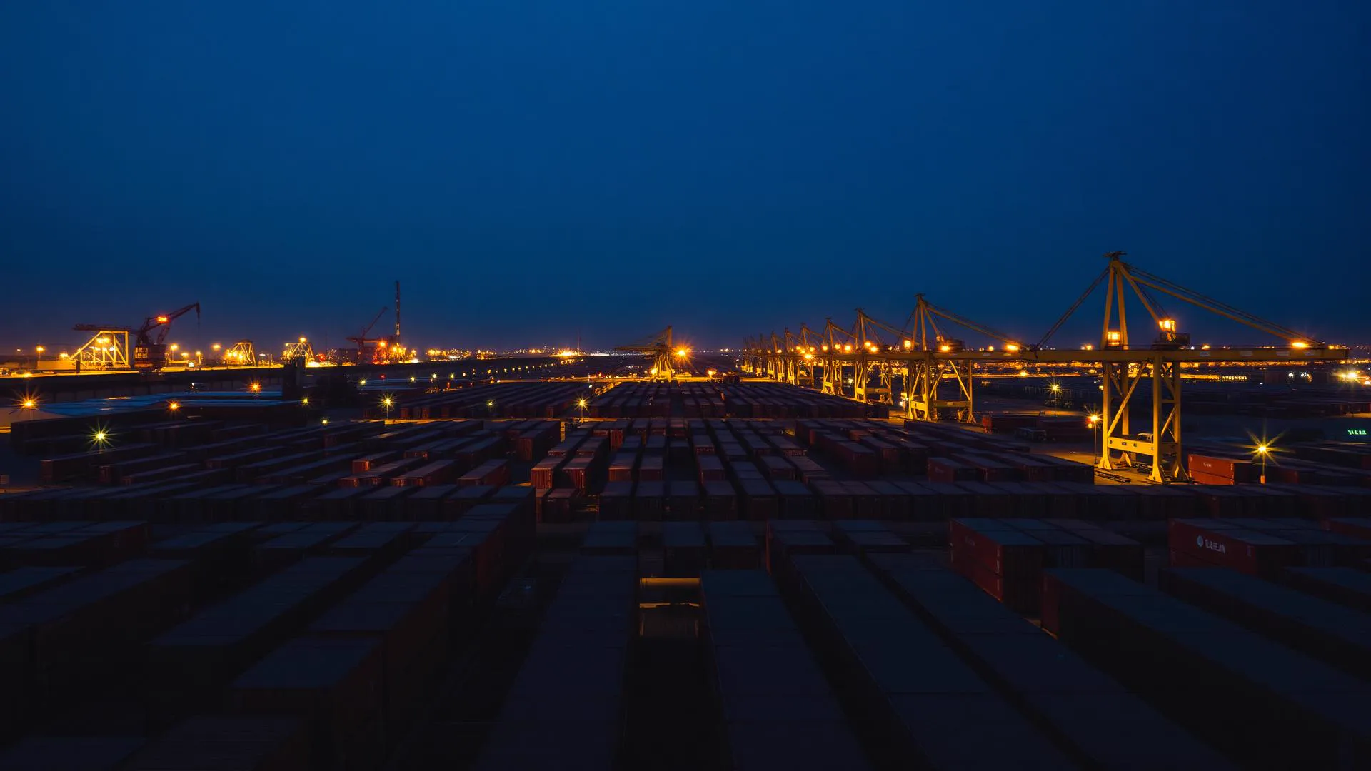 Fábrica Aurex ao entardecer — vista aérea de containers e guindastes